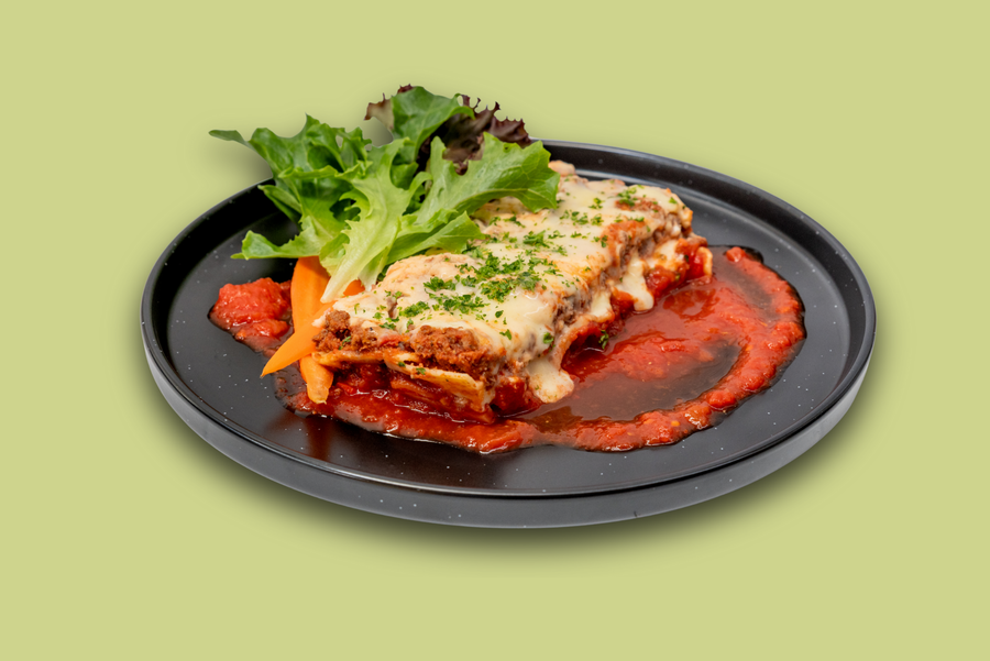 Frozen beef lasagna meal in tray, layered with beef mince, tomato sauce, and melted cheese