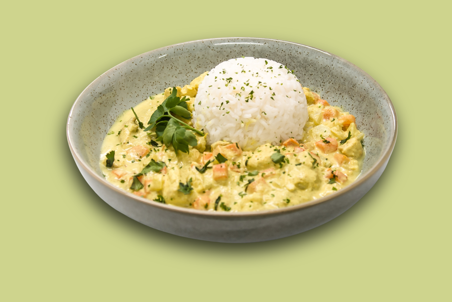 Plated island-style chicken curry with creamy coconut sauce, jasmine rice, and vegetables