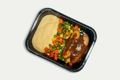 Frozen pork sausages with mashed potatoes, steamed vegetables, and onion gravy